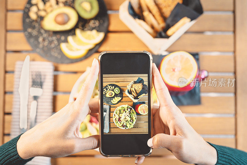 Top view female hands taking photo with mobile smartphone on health lunch food - Young girl having fun with new technology apps for social media - People健康的生活方式和科技上瘾的概念
